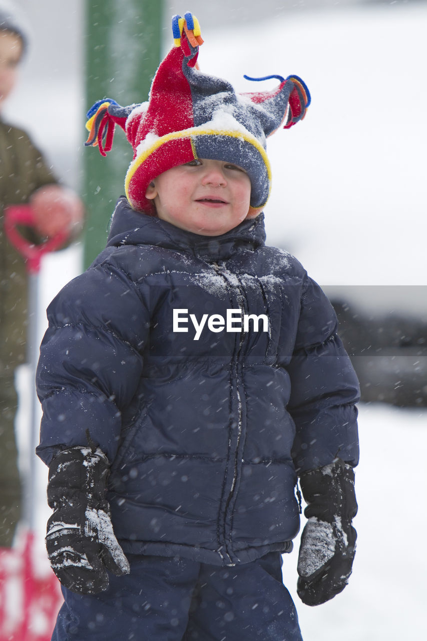 Portrait of boy standing outdoors during winter