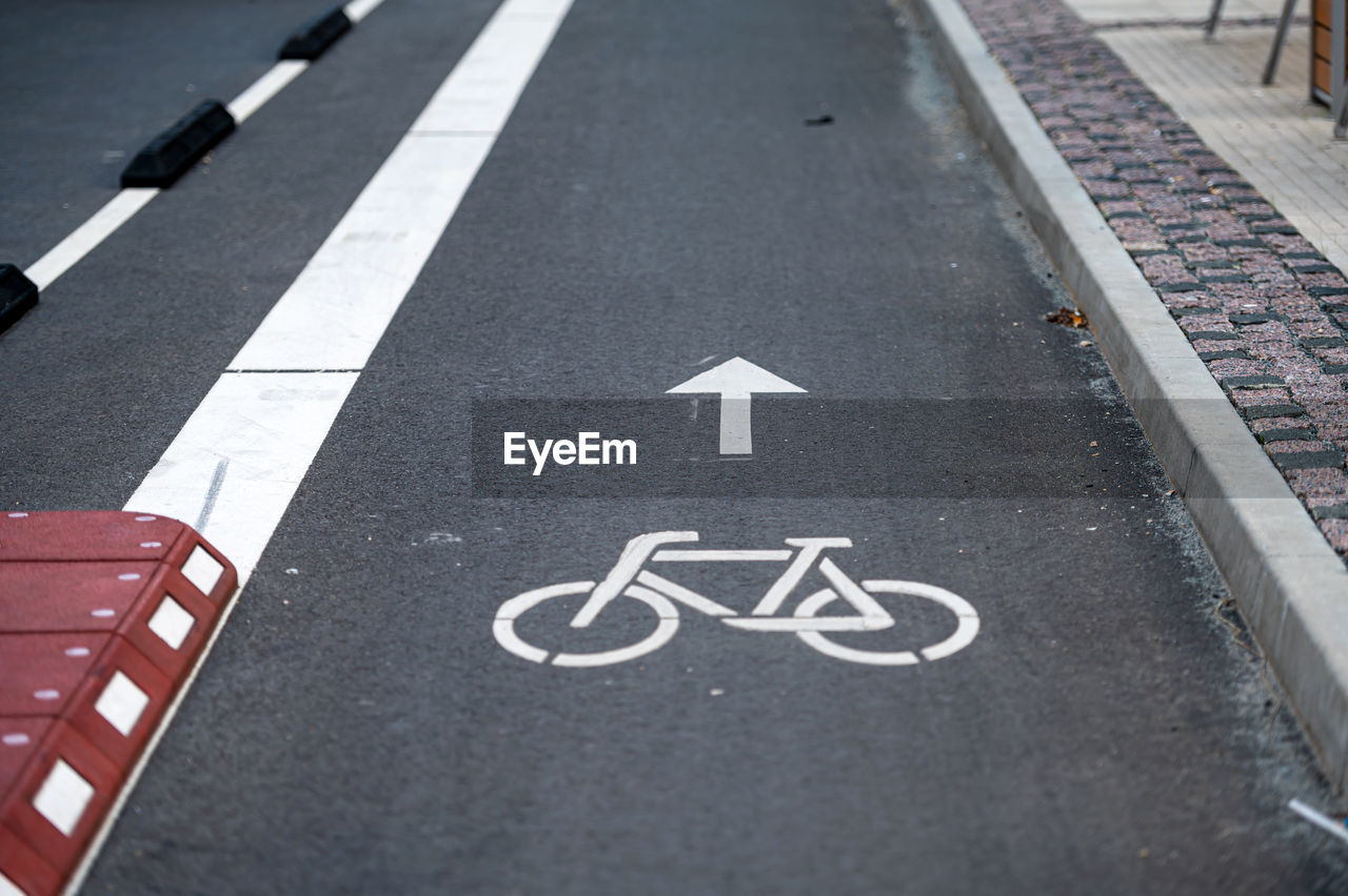 Separate bicycle lane on the street, white painted bike on asphalt, urban traffic and transportation