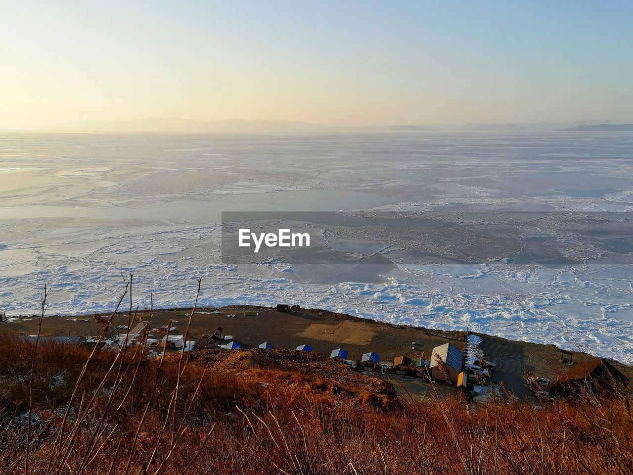 Aerial view of ice covered amur bay of the sea of japan during winter sunset