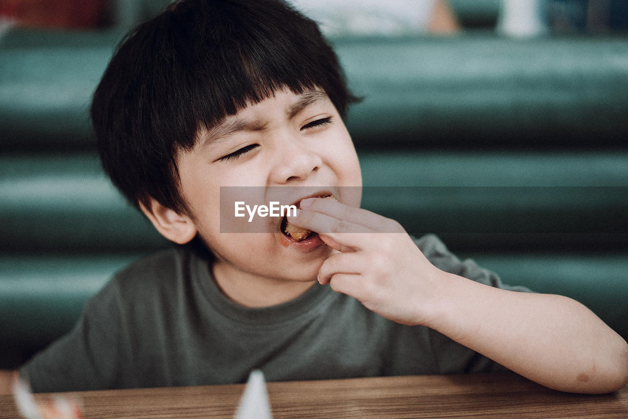 Boy eating ice cream on table