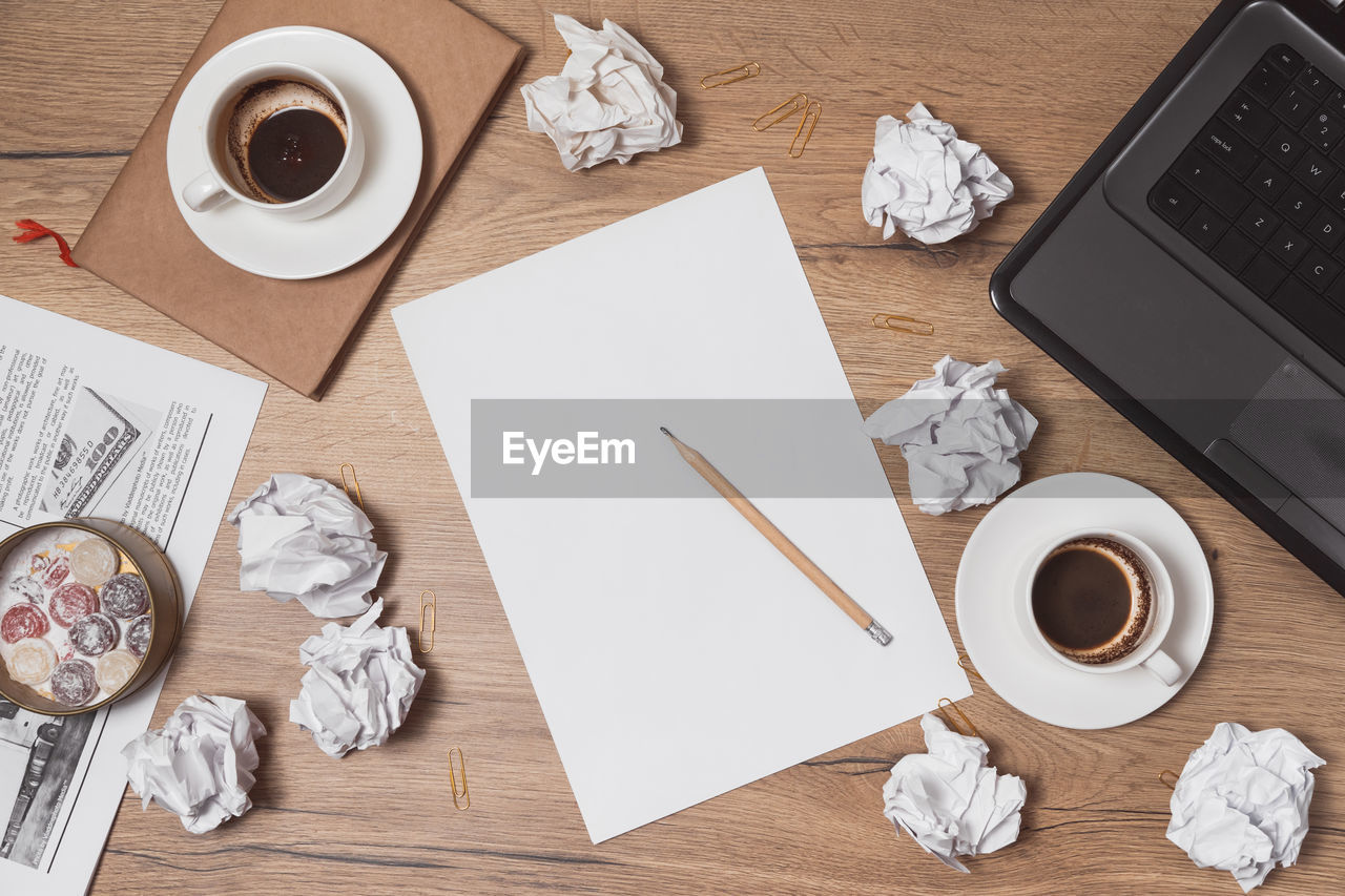 HIGH ANGLE VIEW OF COFFEE CUP AND PAPER