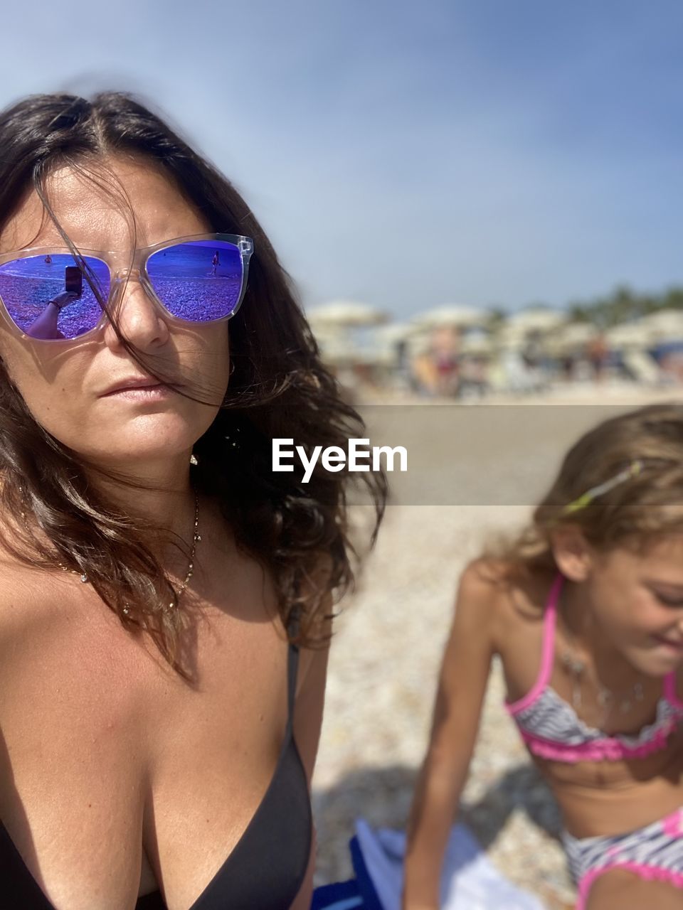 swimwear, women, bikini, beach, summer, holiday, trip, vacation, adult, land, glasses, sunglasses, child, leisure activity, childhood, female, water, clothing, two people, nature, fashion, togetherness, swimsuit top, sea, suntan lotion, portrait, long hair, day, hairstyle, spring break, emotion, photo shoot, front view, brown hair, brassiere, friendship, family, fun, sunlight, sand, outdoors, young adult, focus on foreground, headshot, lifestyles, waist up, smiling, relaxation, happiness, travel, sun tanning, sky, enjoyment, teenager, blue, looking, weekend activities, carefree