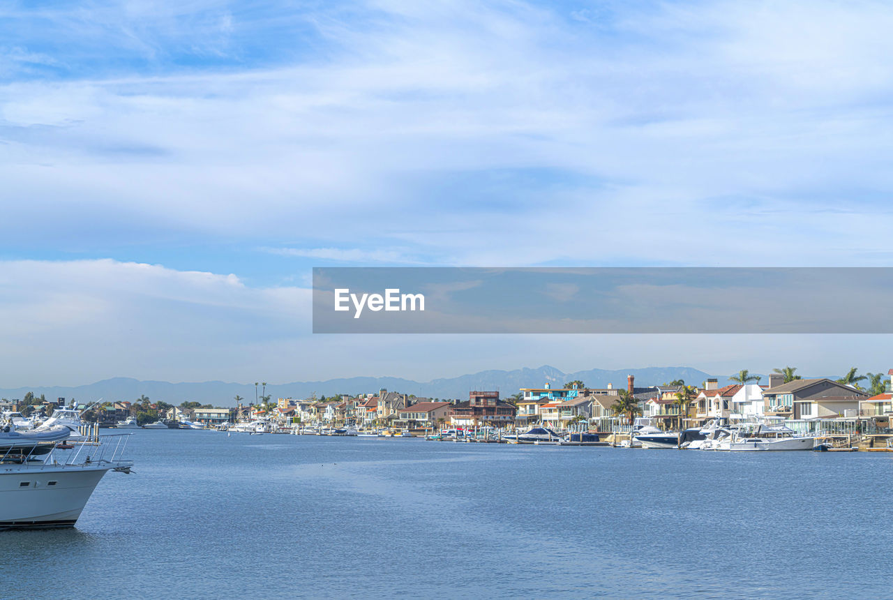 SEA BY TOWNSCAPE AGAINST SKY