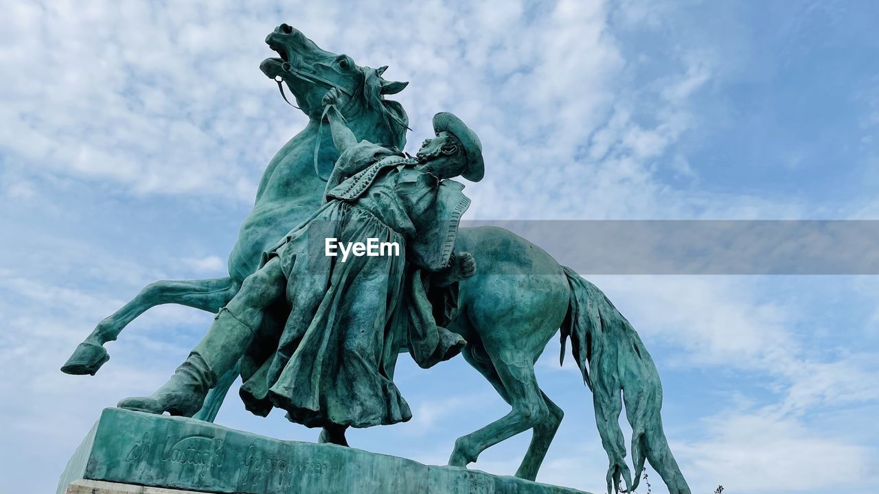 statue, sculpture, horse, human representation, representation, sky, art, nature, cloud, architecture, monument, the past, history, memorial, no people, travel destinations, low angle view, blue, male likeness, day, travel, craft, outdoors, animal representation, livestock, green