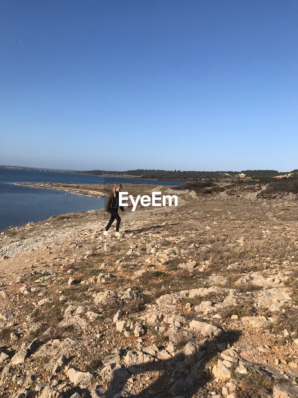 MAN ON SHORE AGAINST SKY