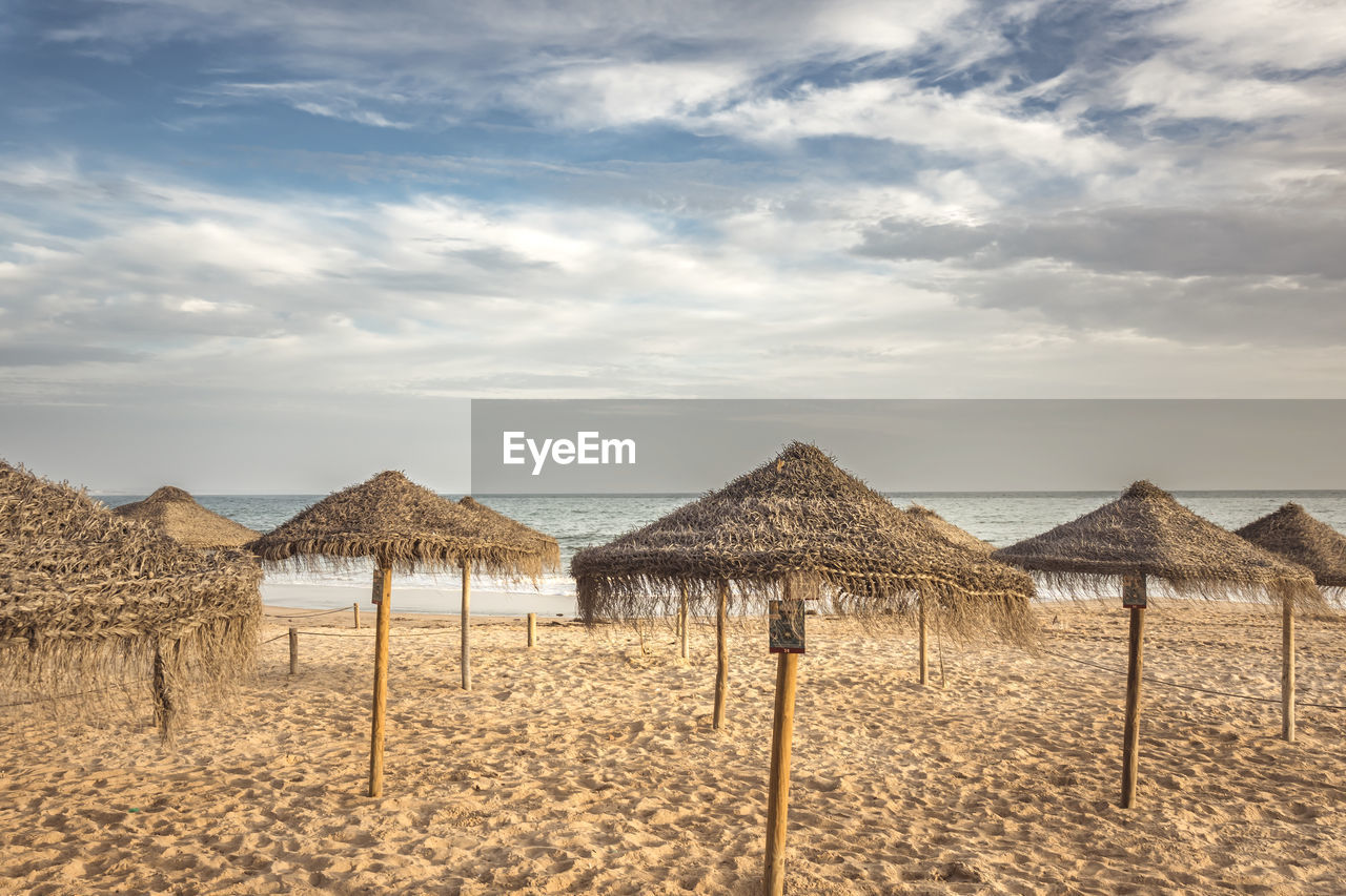 Straw umbrellas on a sandy beach. relaxing day on a exotic beach in summer