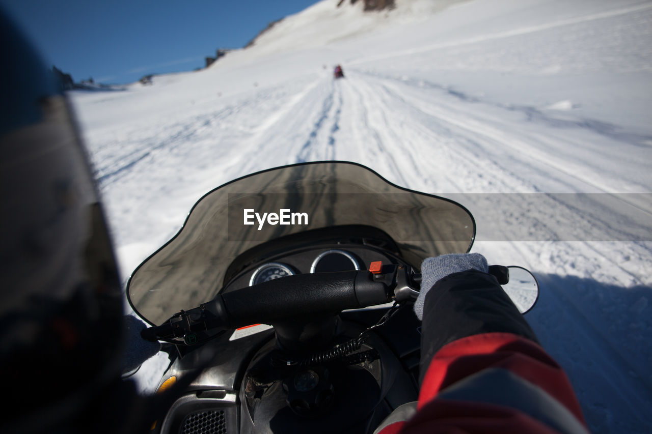 Person riding snowmobile on mountains