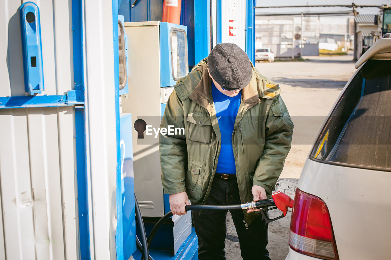 Man filling fuel in car