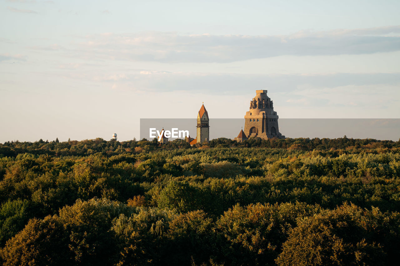 Monument of the battle of the nations with the cemetry church over the treeline