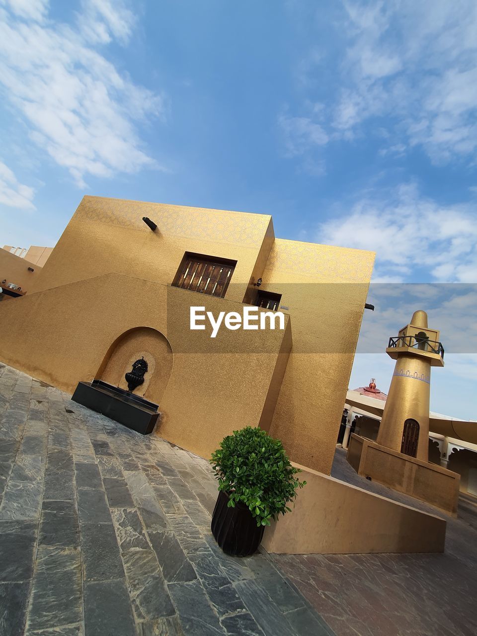 LOW ANGLE VIEW OF TRADITIONAL BUILDING BY PLANTS AGAINST SKY