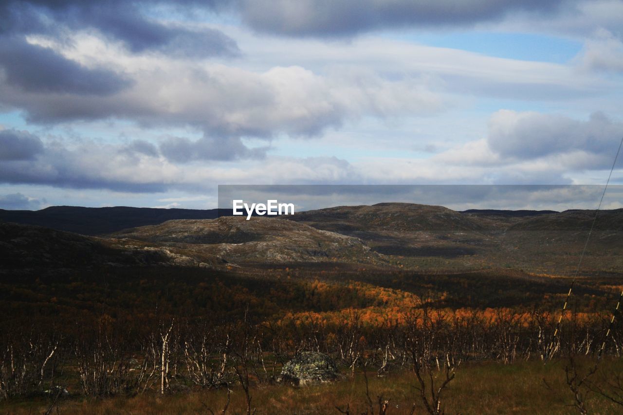 SCENIC VIEW OF MOUNTAINS AGAINST CLOUDY SKY