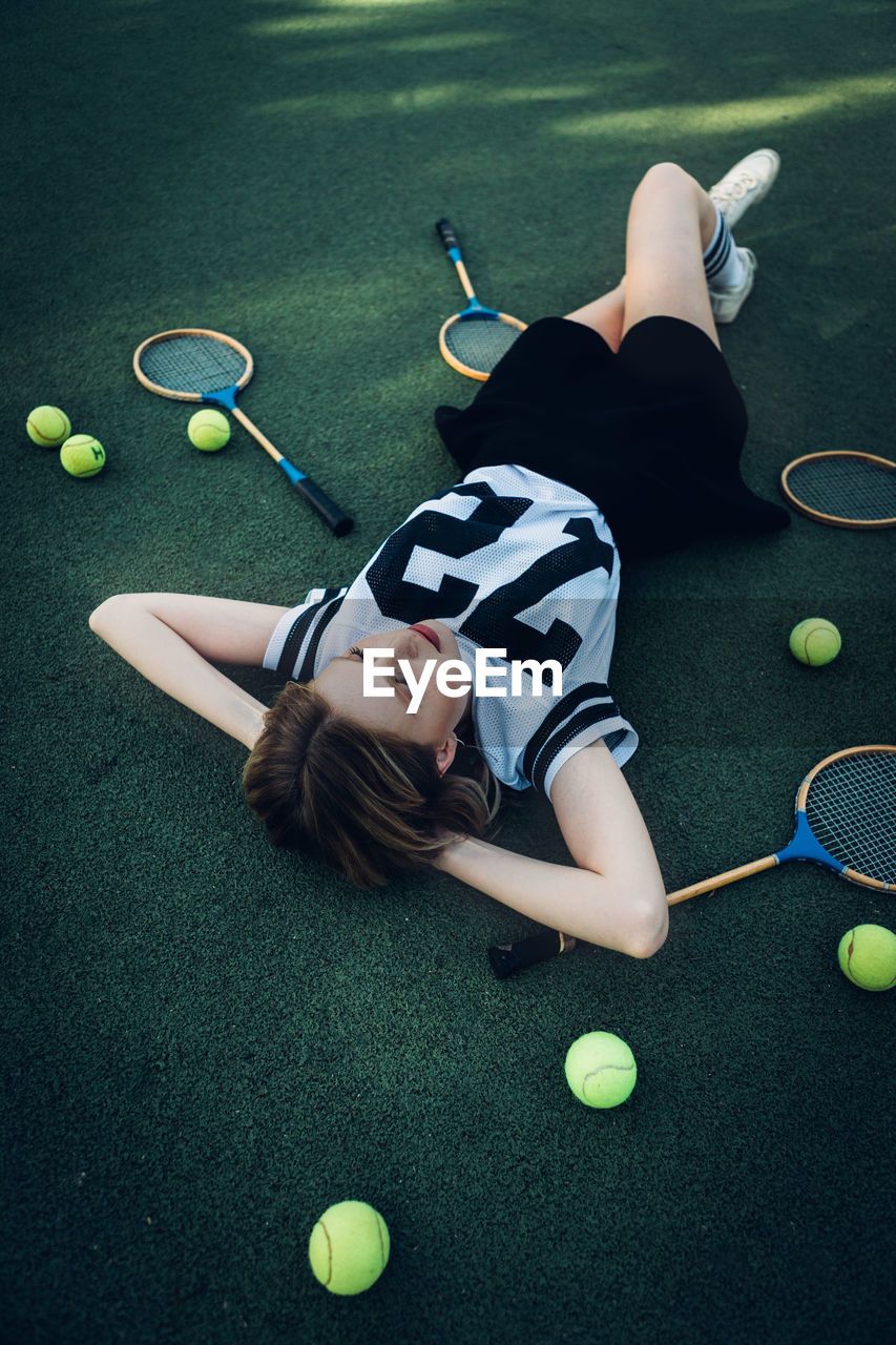 High angle view of tired young woman lying on court