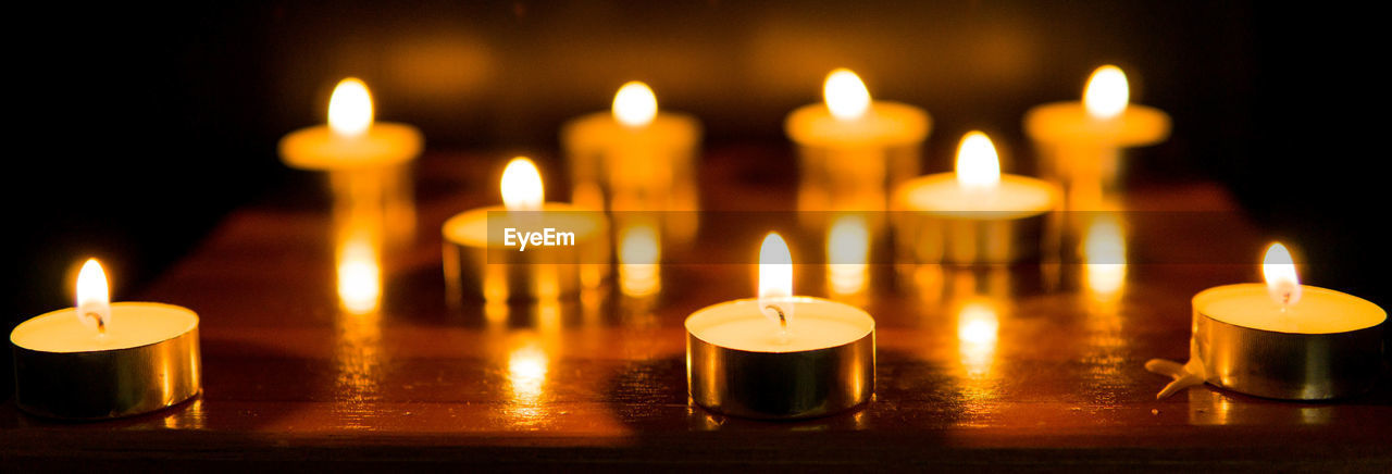 Many candles burn with a shallow depth of field.