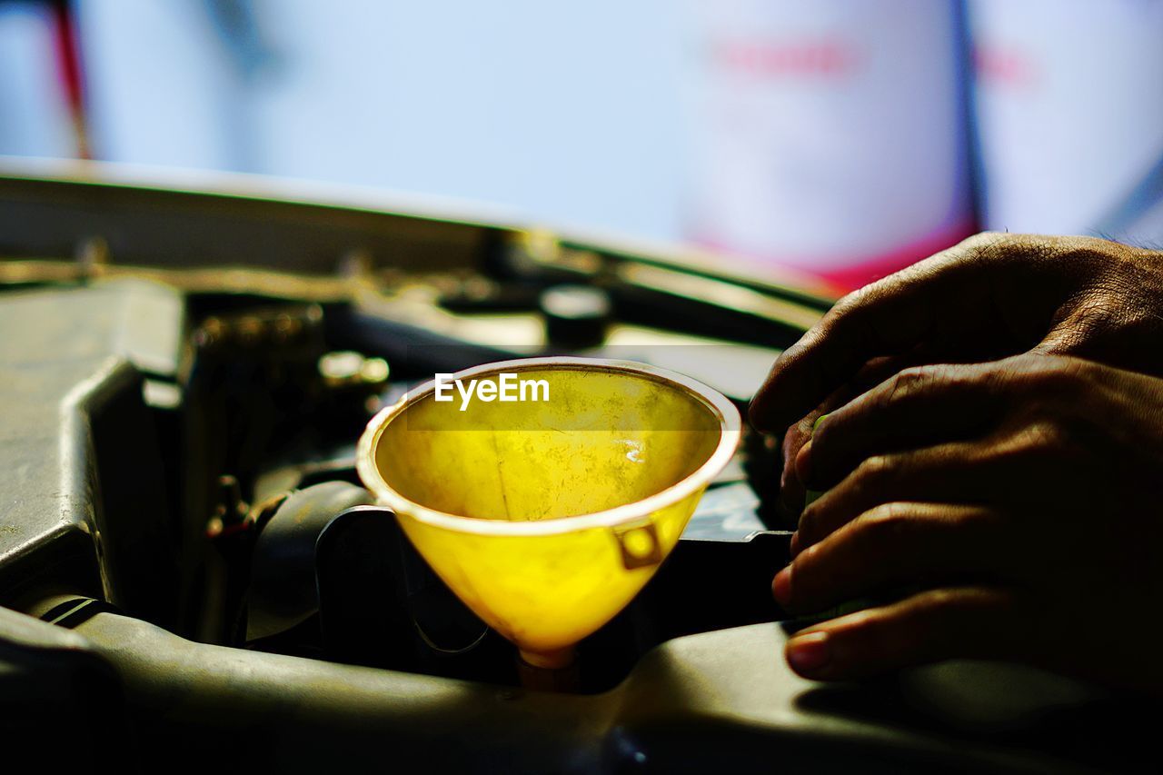 Close-up of hand holding engine oil 