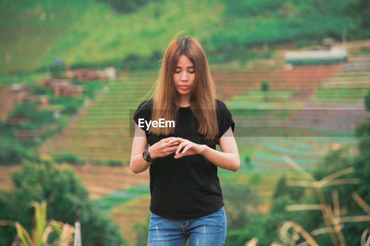 Young woman standing on agricultural field