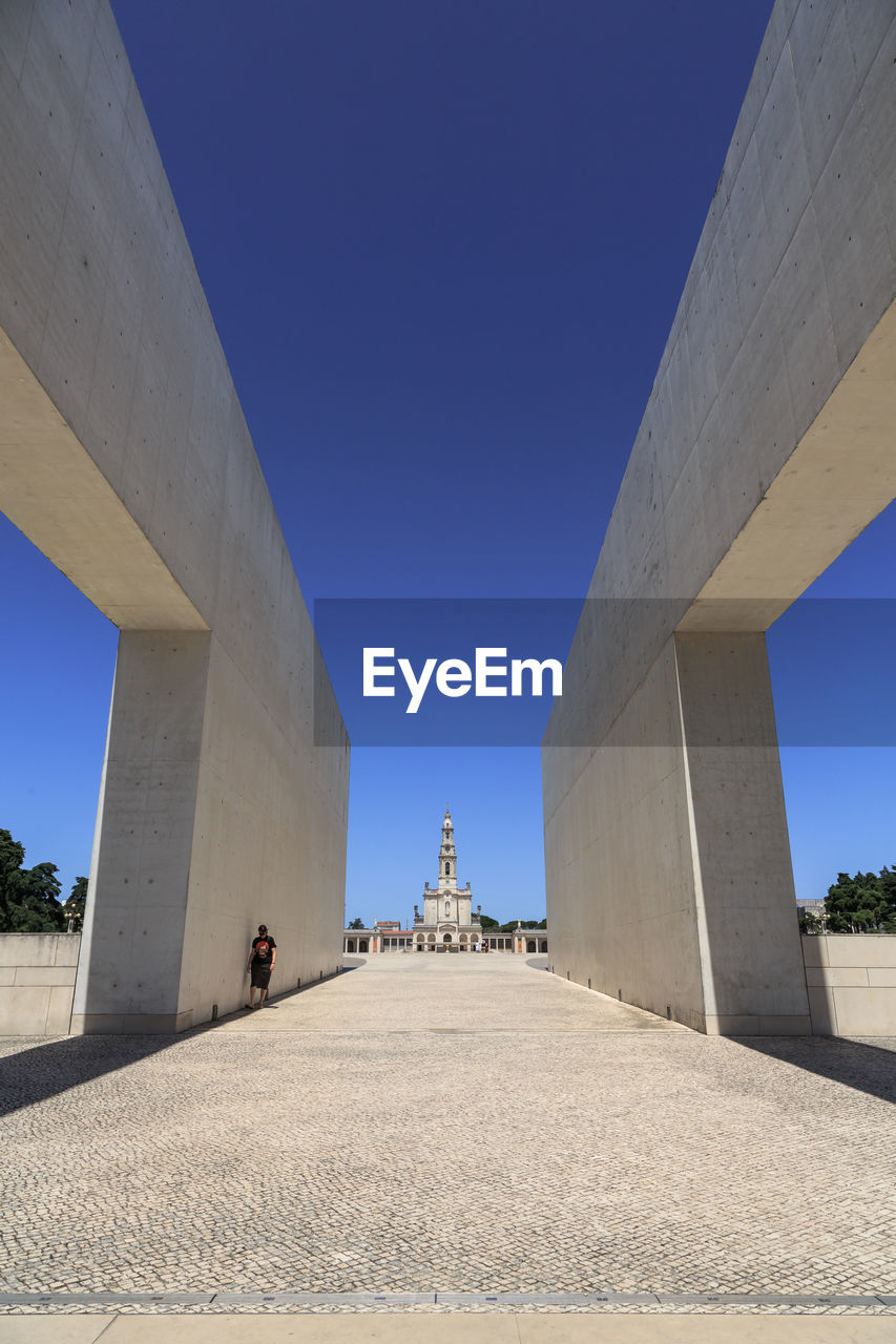 architecture, built structure, landmark, sky, blue, clear sky, nature, travel destinations, city, travel, transportation, day, outdoors, monument, sunny, arch, building exterior, concrete, road, bridge, adult