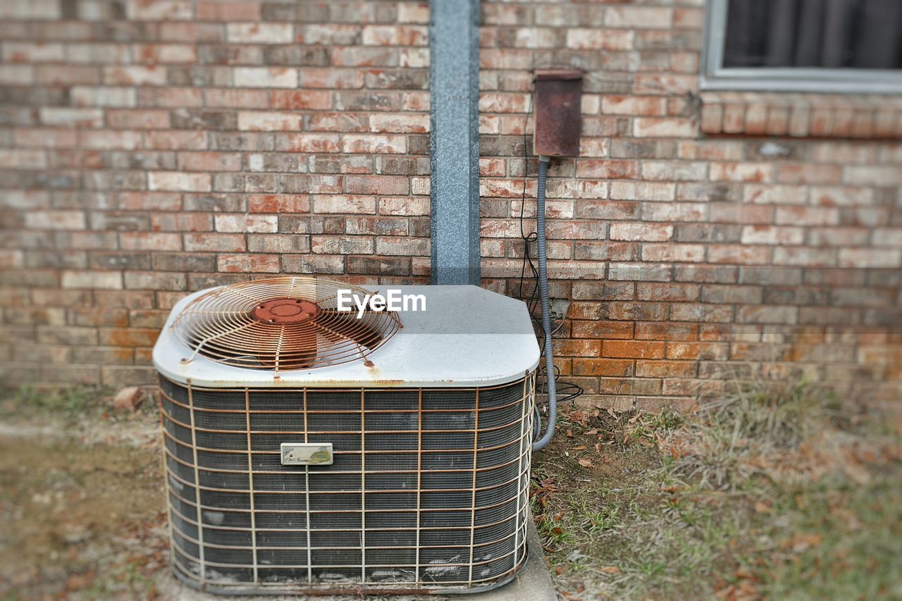 High angle view of rusty industrial machinery against building wall
