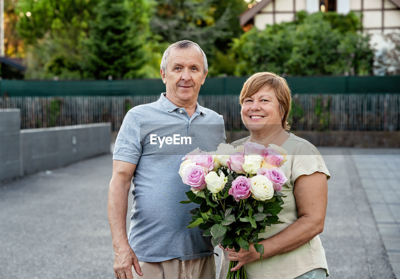 portrait of smiling couple standing against wall