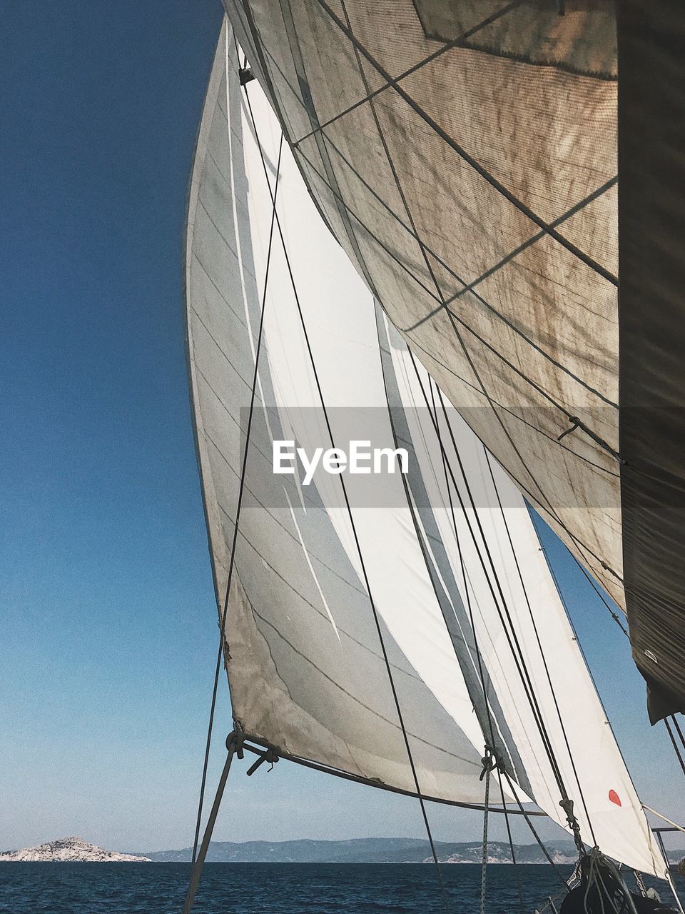LOW ANGLE VIEW OF BOAT SAILING IN SEA AGAINST CLEAR SKY