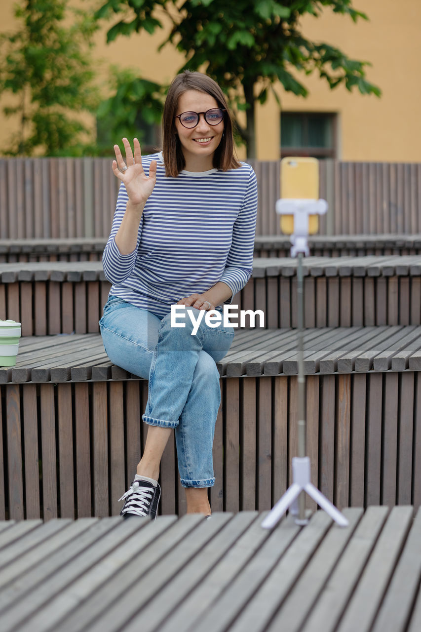 Portrait of smiling woman vlogging outdoors