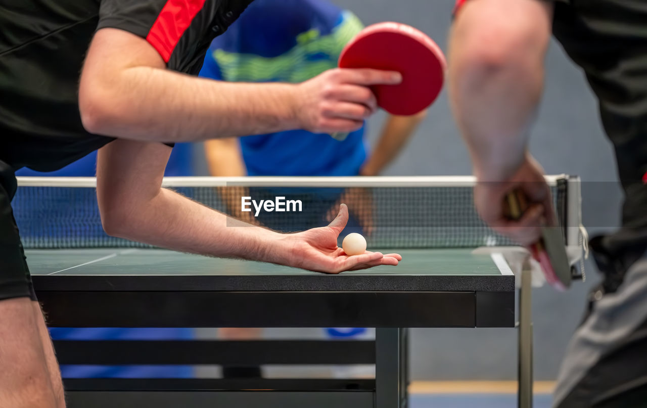 Table tennis player serving in a table tennis championship match