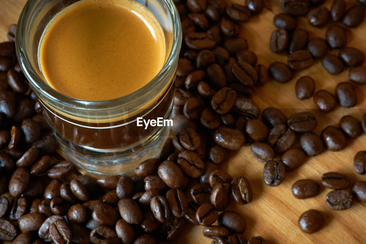 High angle view of coffee with roasted beans on table