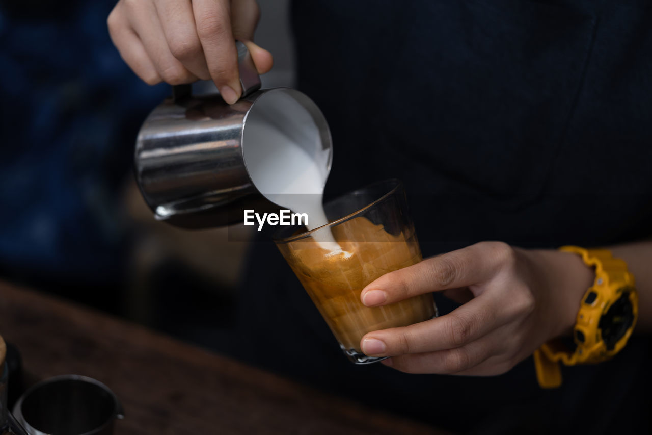 Midsection of person preparing coffee