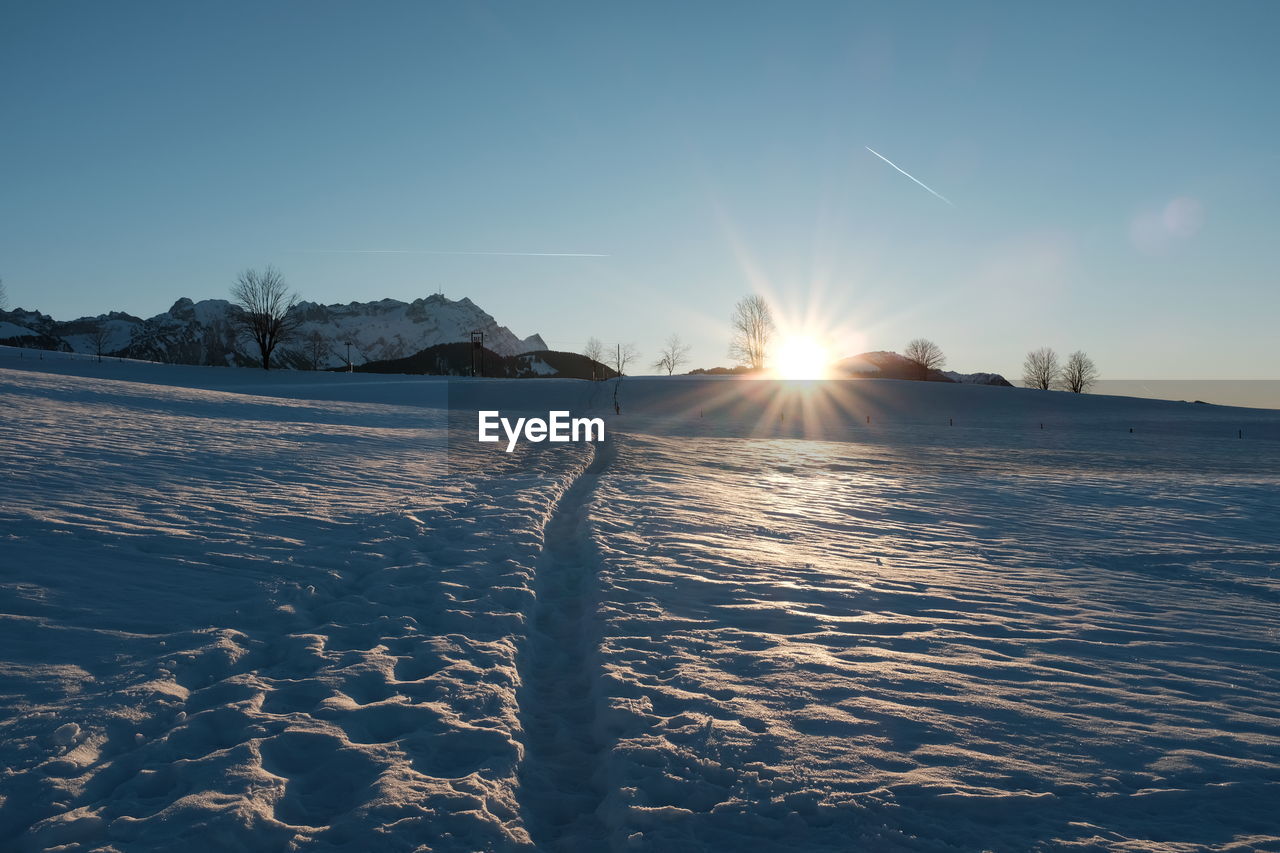 FROZEN LAKE AGAINST SKY DURING WINTER