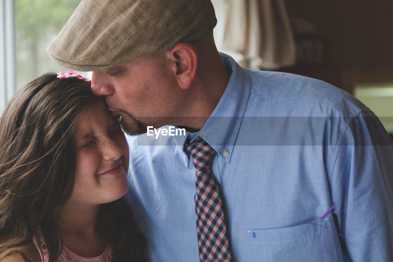 Close-up of father kissing daughter