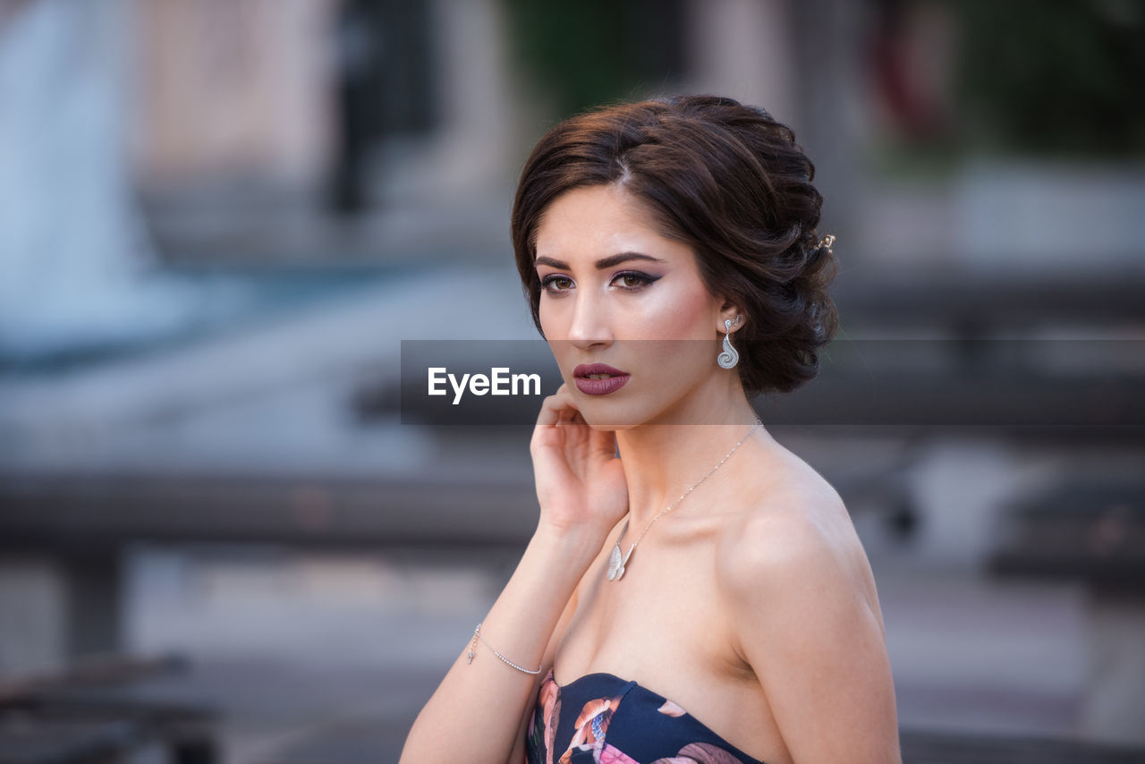 Portrait of beautiful woman against blurred background