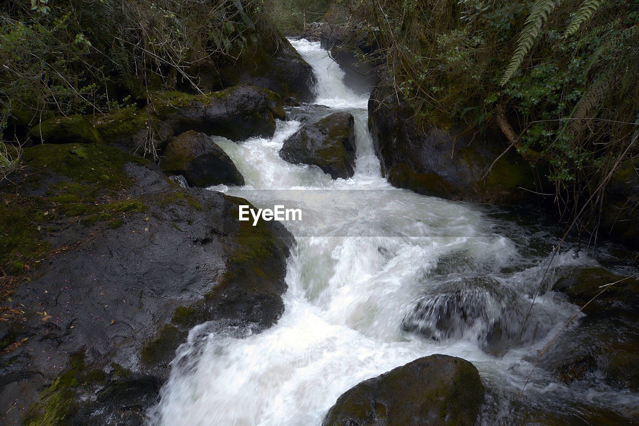 CLOSE-UP OF WATER FLOWING OVER WATERFALL