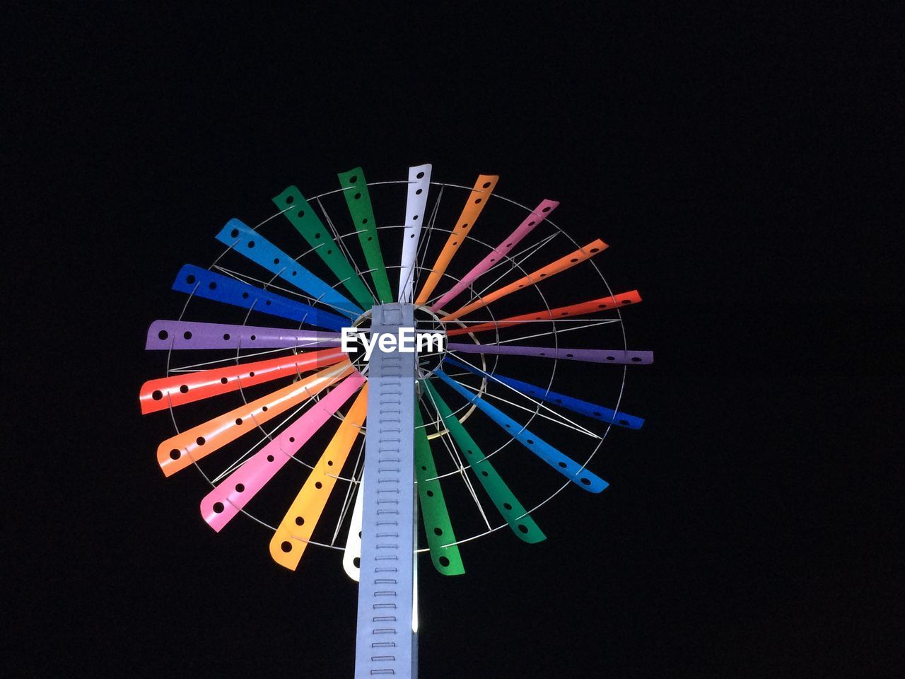 Low angle view of illuminated ferris wheel against sky at night