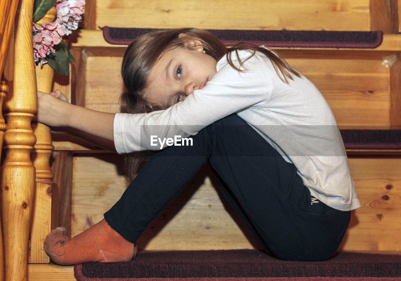 Side view of woman sitting on steps