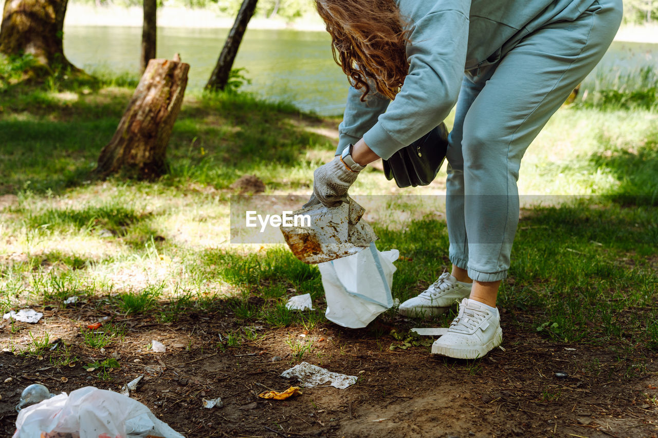 one person, nature, plant, adult, tree, casual clothing, lifestyles, day, grass, shoe, women, leisure activity, footwear, low section, environment, outdoors, land, clothing, standing, lawn, spring, human leg, bag, person, sunlight