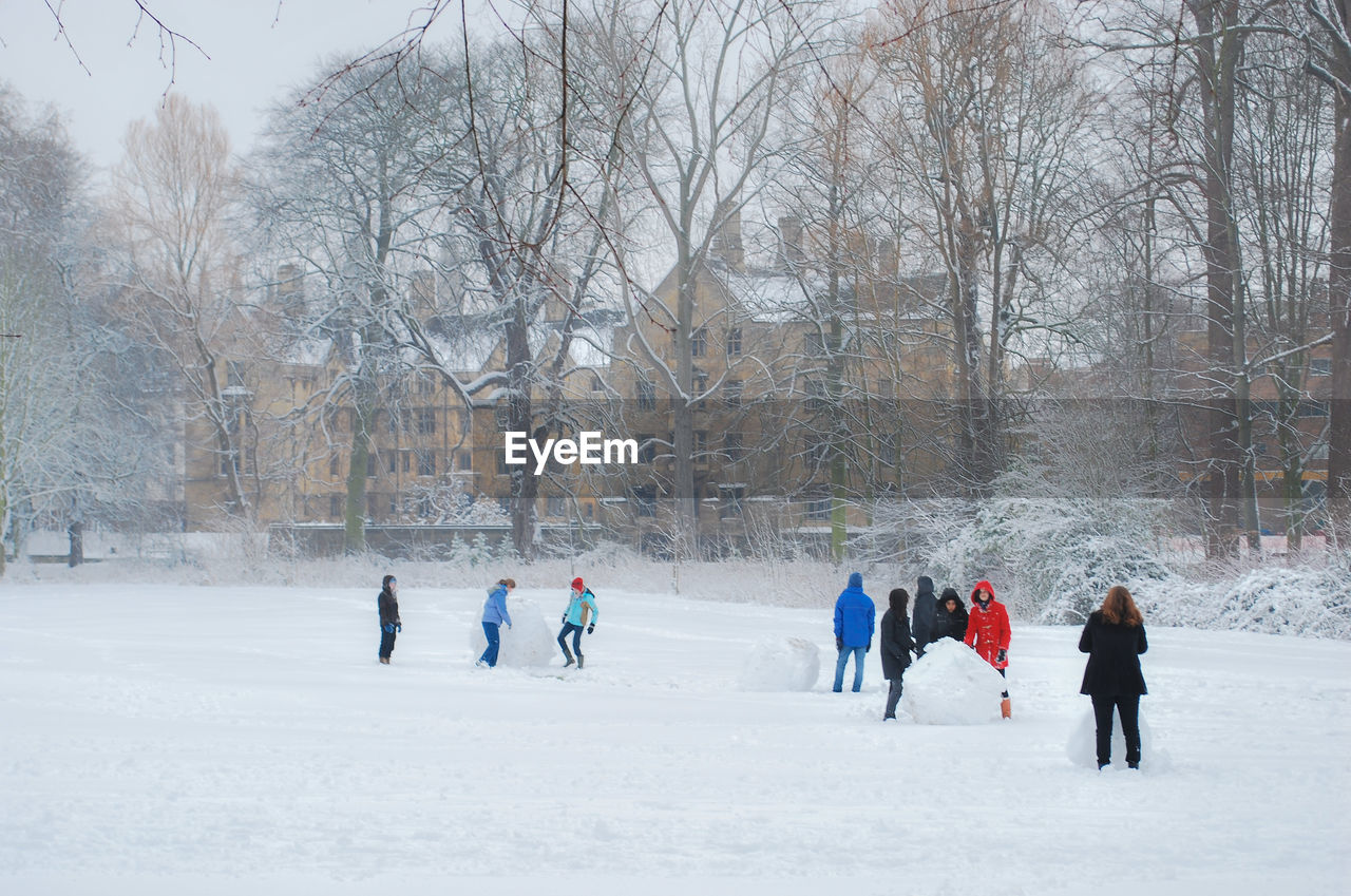 PEOPLE WALKING ON SNOW COVERED LANDSCAPE