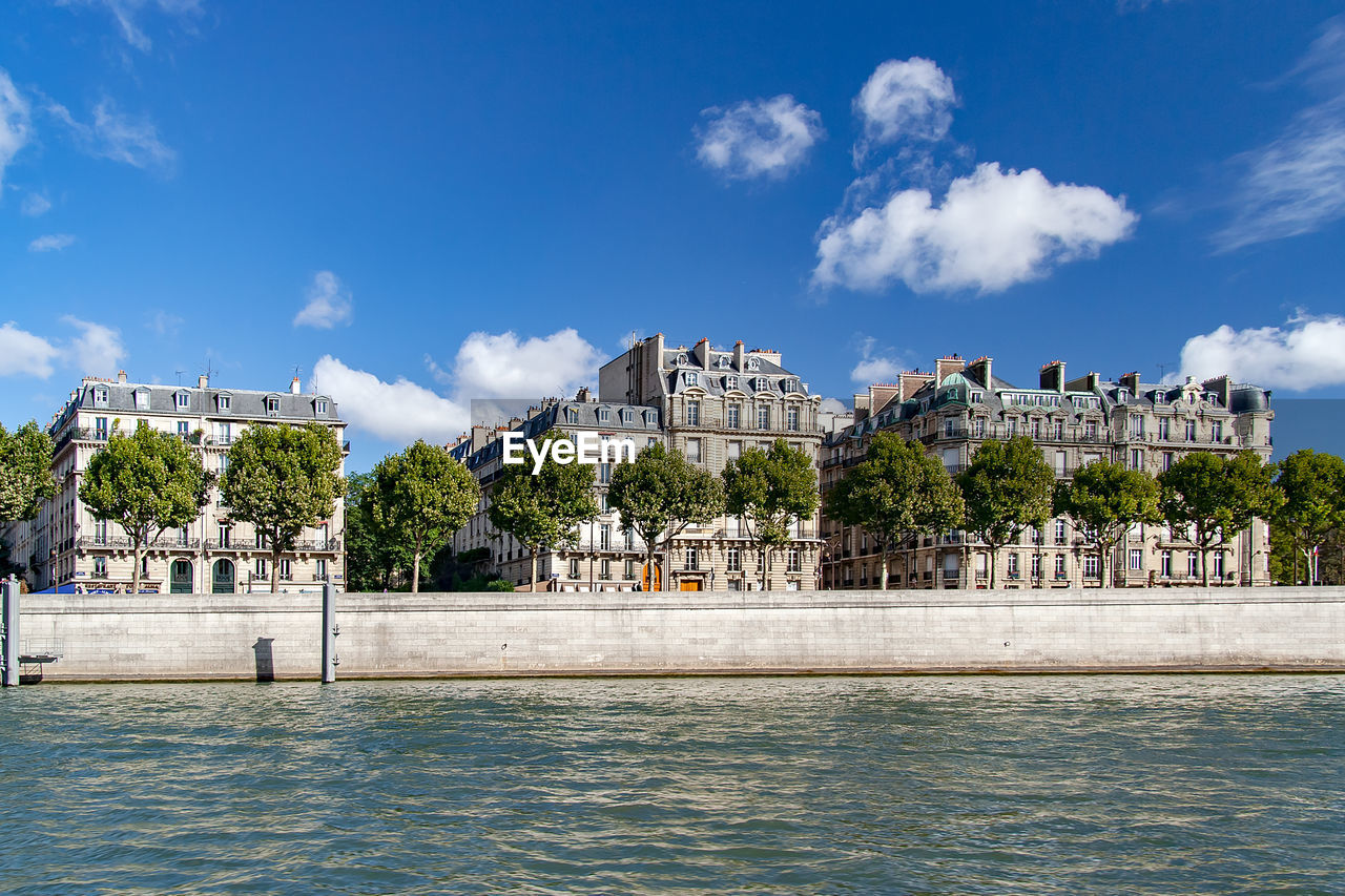 Buildings at waterfront  against sky