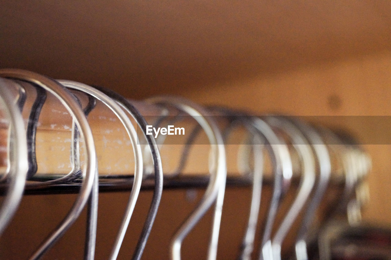 Close-up of coathangers hanging in wardrobe