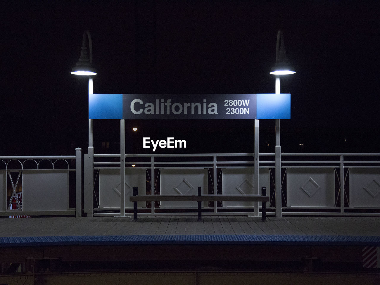 Text on structure and lighting equipment at railroad station platform