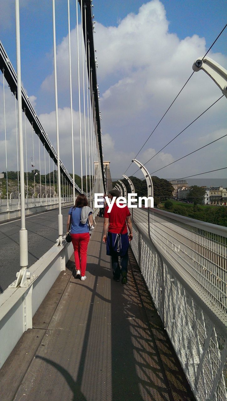 Rear view of couple walking on bridge