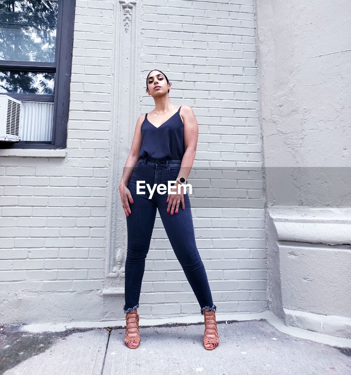 Portrait of woman standing against wall