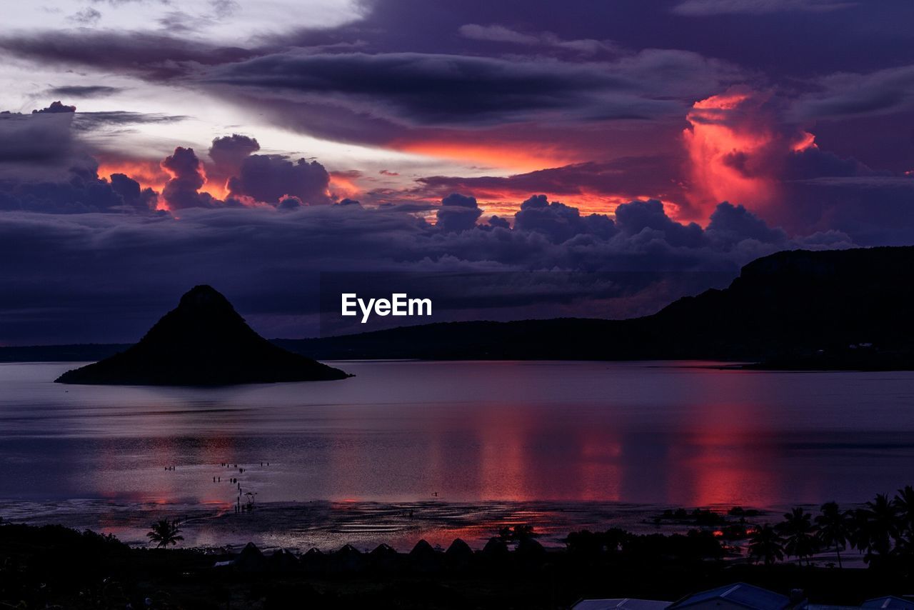 Scenic view of sea against dramatic sky during sunset