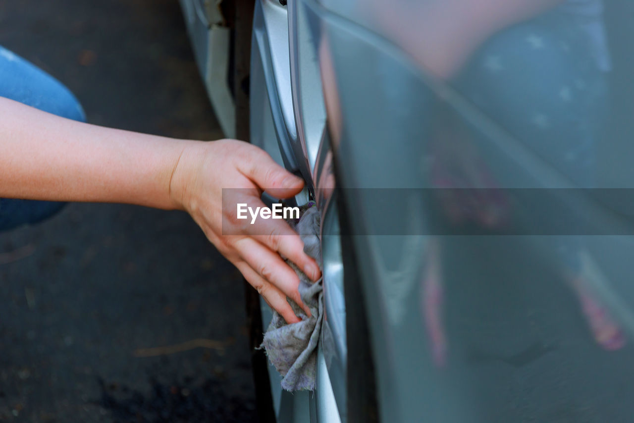 Midsection of woman cleaning car