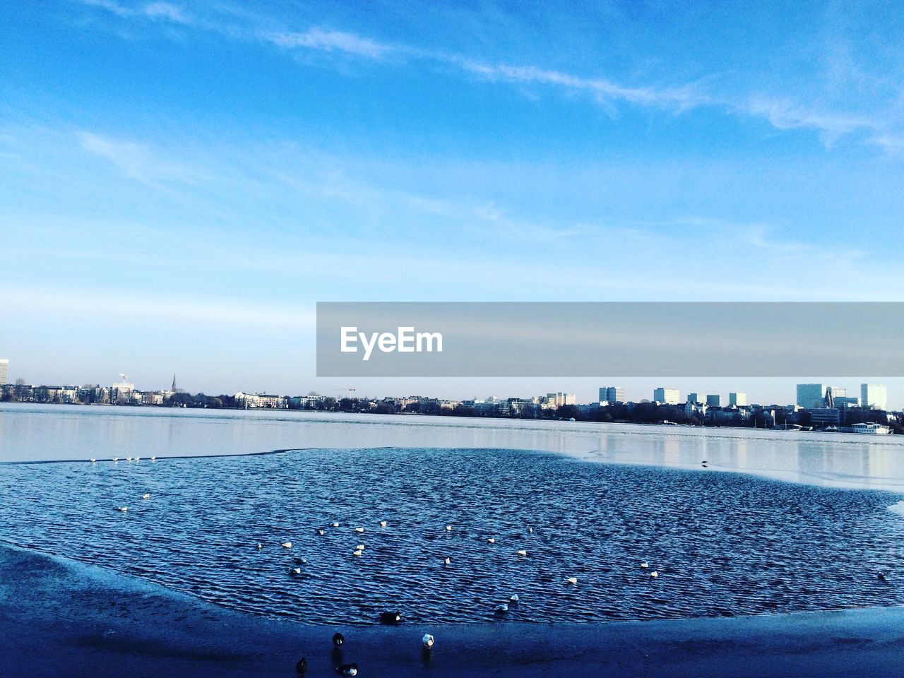 Scenic view of sea against cloudy blue sky on sunny day