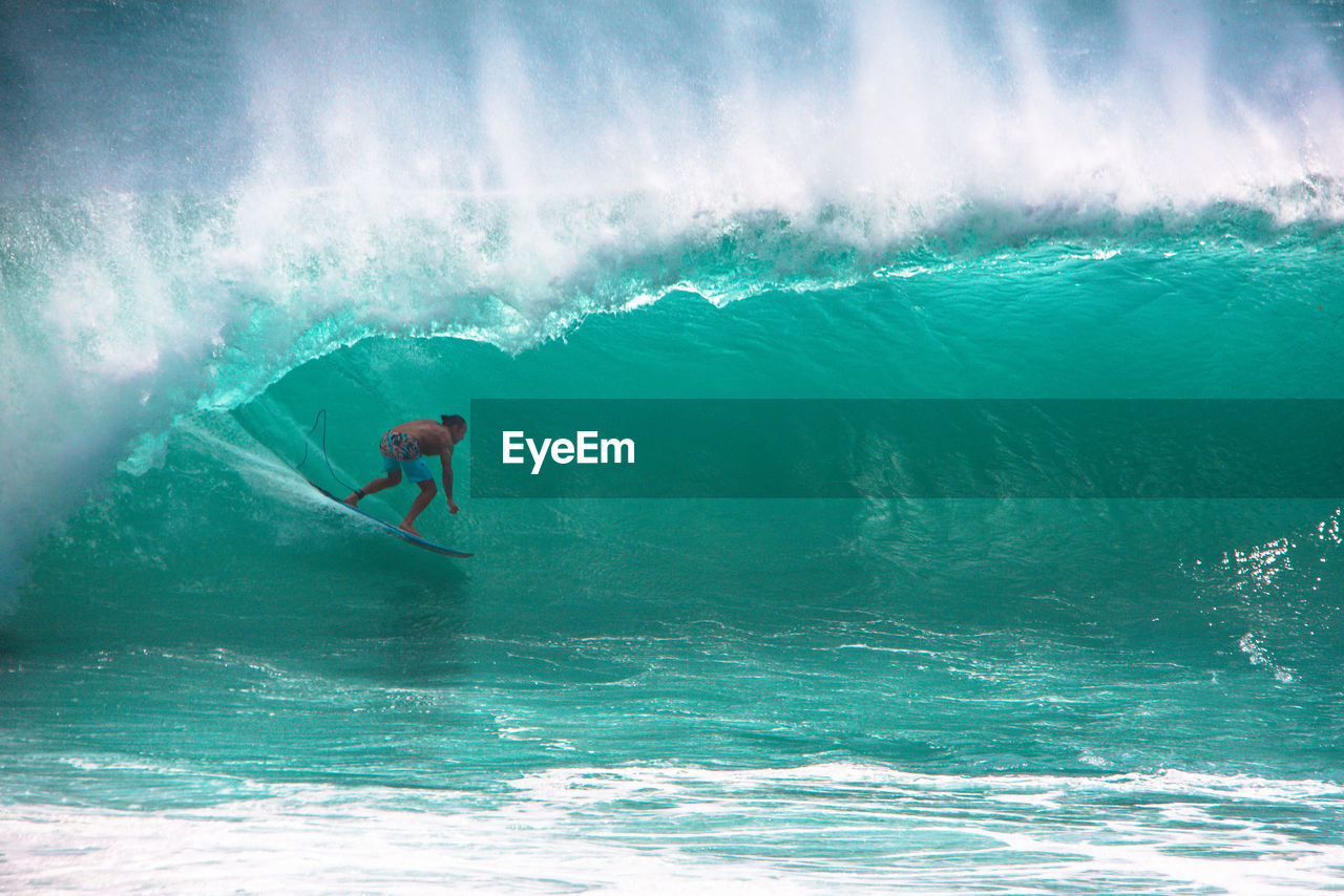 Man surfing in sea against sky