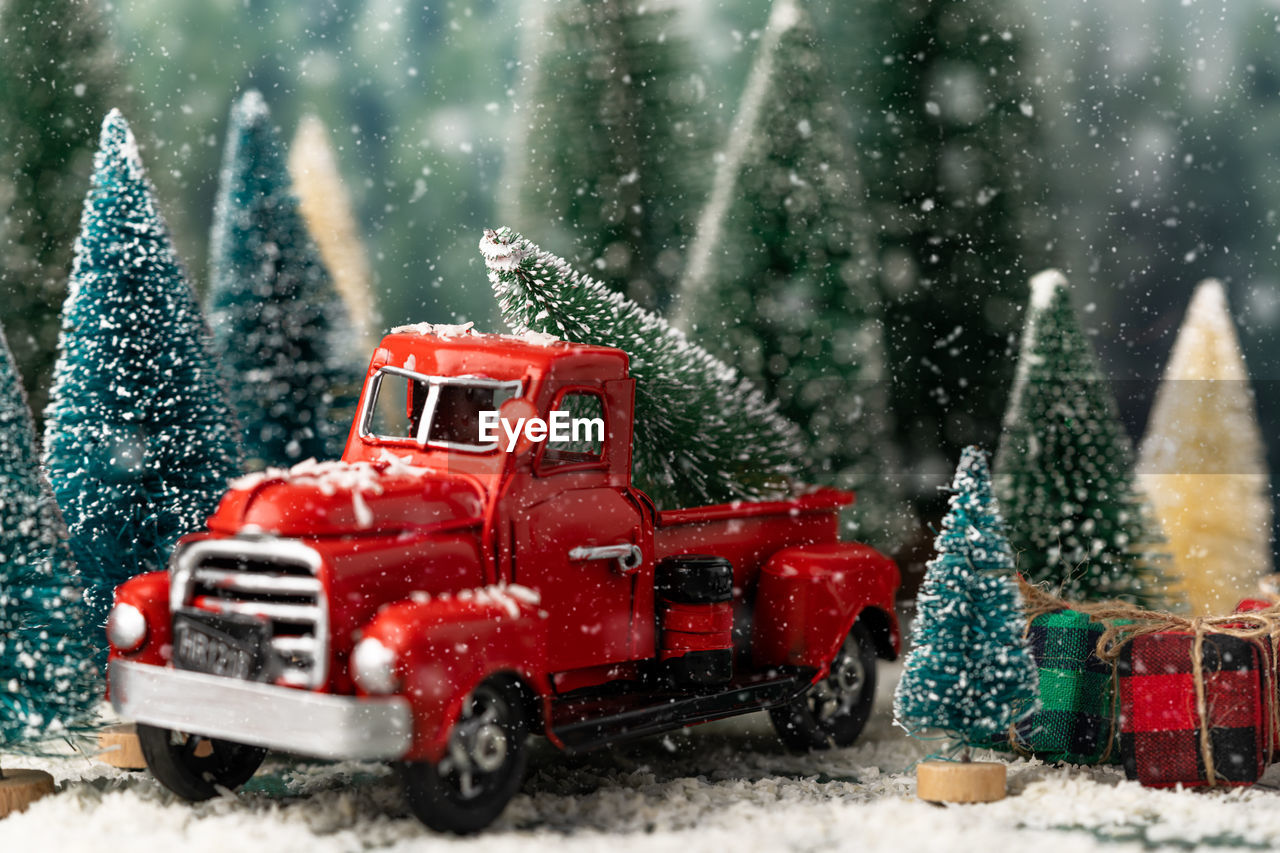 Red truck and christmas tree in snow
