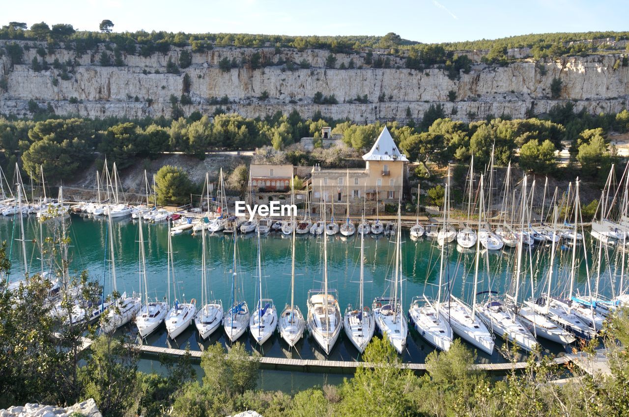 Sailboats moored on river by buildings in city