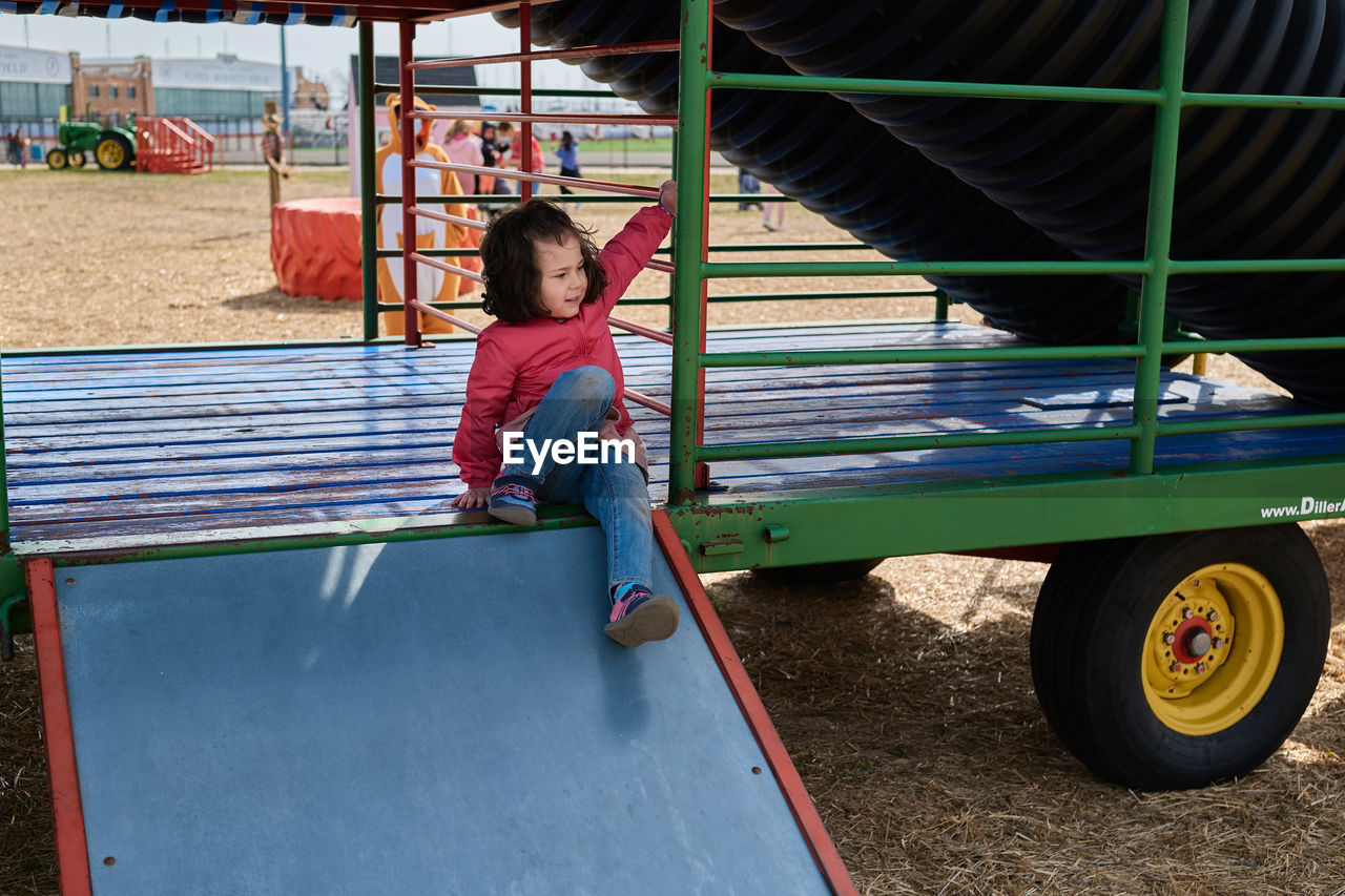 Young girl in a mask playing with attractions at the county fair