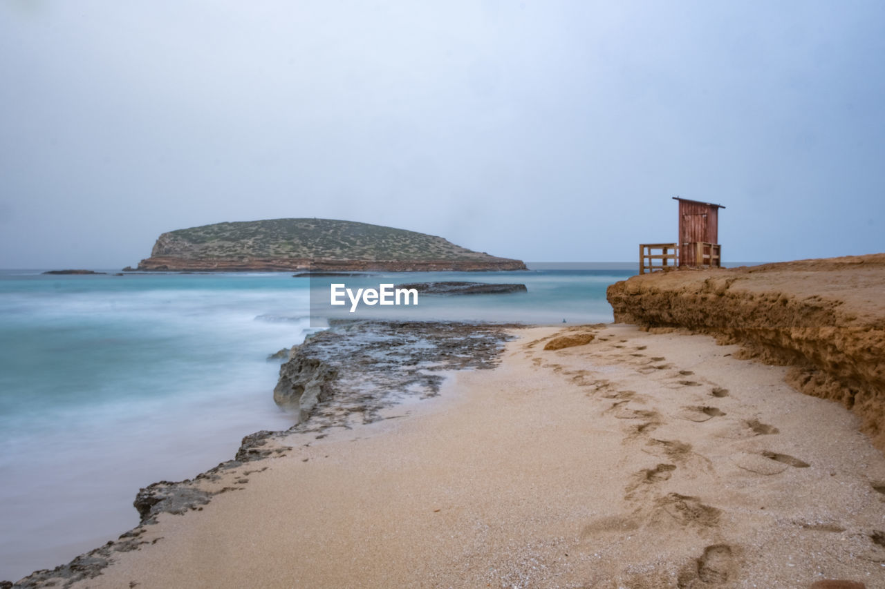 Scenic view of beach by sea against sky