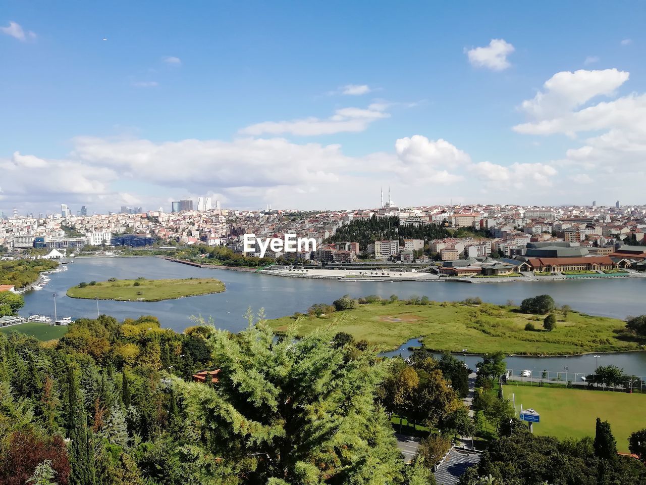 RIVER AMIDST TOWN AGAINST SKY