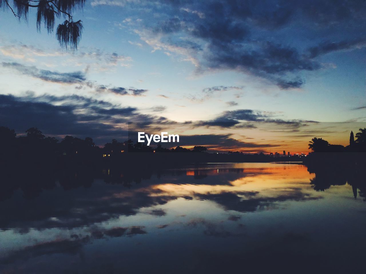 SCENIC VIEW OF LAKE AGAINST DRAMATIC SKY